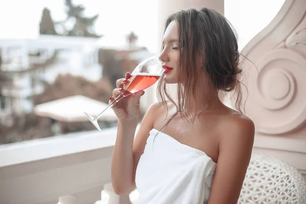 Beautiful brunette woman in white bath robe enjoying glass of ch — Stock Photo, Image