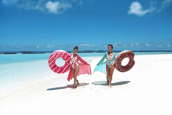 Vacaciones de verano. Feliz dos mujeres libres con floa inflable del donut —  Fotos de Stock