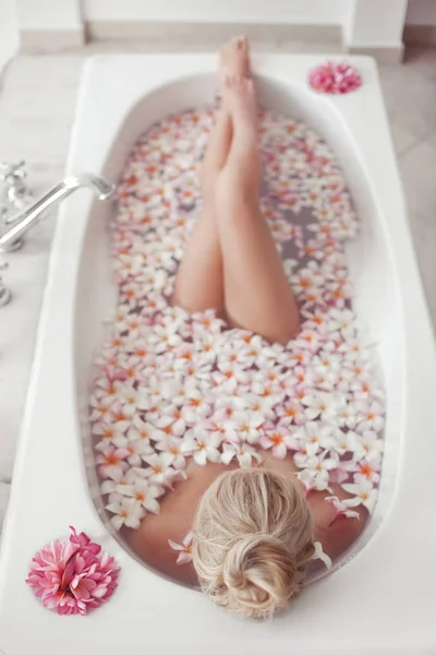 Spa Relájate. Rubia disfrutando de baño con plumeria flores tropicales . —  Fotos de Stock