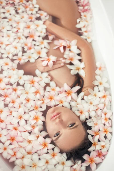 Σπα χαλαρώστε. Όμορφη γυναίκα που απολαμβάνει μπάνιο με πλάμες τροπικό — Φωτογραφία Αρχείου