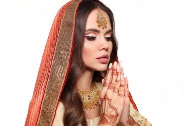 Mehendi. Geleneksel sarili güzel Hintli kız portresi beyaza izole edilmiş. Kundan altın mücevher setiyle genç Hindu kadın model. Hint kostümü Lehenga choli. Kına el boyuyor..