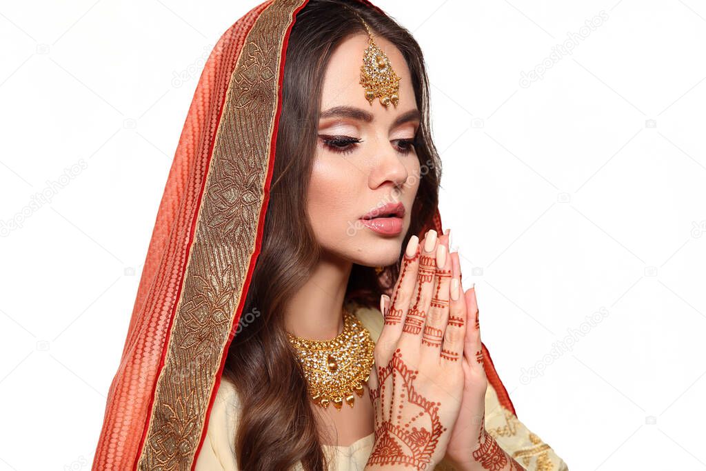 Mehendi. Portrait of beautiful indian girl in traditional saree isolated on white. Young hindu woman model with kundan golden jewelry set. Indian costume lehenga choli. Henna painting hands.