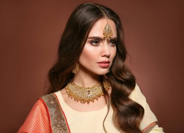 Sari giymiş güzel Hintli kız portresi. Kundan altın mücevher setiyle genç Hindu kadın model. Geleneksel Hint kostümü lehenga choli. 