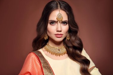 Sari giymiş güzel Hintli kız portresi. Kundan altın mücevher setiyle genç Hindu kadın model. Geleneksel Hint kostümü lehenga choli. 