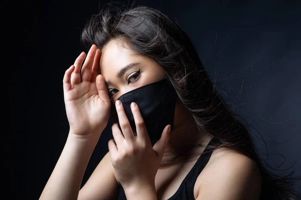 beautiful asian girl in protective black mask. Fashionable stylish trend portrait. Fashion new quarantine normal. Accessory elegant vogue glamour. makeup asia eyes.  Covid-19.  copyspace banner
