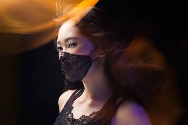 Siyah maskeli güzel bir Asyalı kız portresi. Moda aksesuarı. Koruyucu tasarım. Vogue fotoşopu. Coronavirus koruması covid 19 pandemik karantina