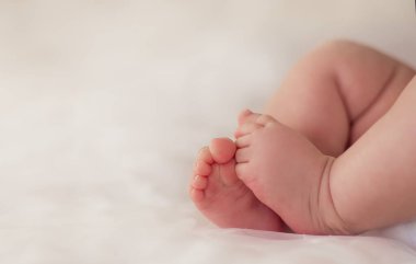 Beyaz arka planda yeni doğmuş bir bebeğin minik topukları. Yeni doğan bebeğin ayakları küçük ayak parmaklarıdır. Şefkat, yavruların bakımını kolaylaştırır. Ebeveynlik. Pediatri, neonatoloji. Doğum. Güzel bebek, sevimli hassas.