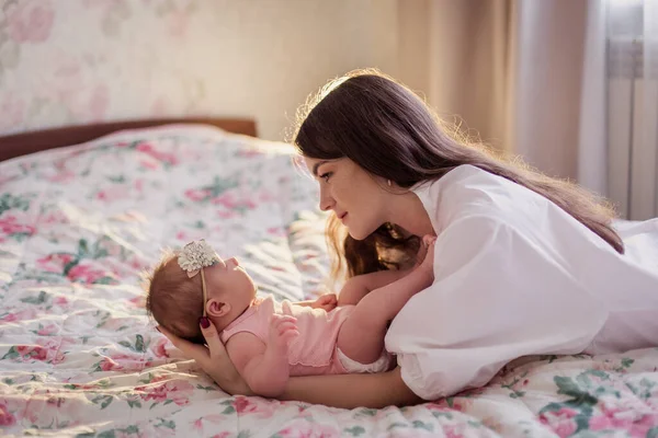 Mutlu, genç bir anne ve bebeği evde, yatağında. Yeni doğmuş bebek ve anne birlikte. Annelik canlı yayında. Çocukluk. Şefkat bakımı. Kafkasyalı kadın ve çocuk. Yatak odası.