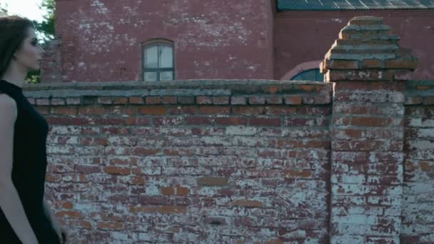 Goottilainen nuori nainen lähellä vanhaa rakennusta — kuvapankkivideo