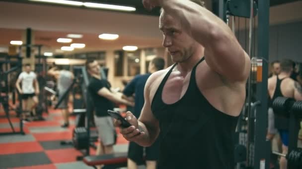 Bodybuilder in sportschool doen selfie — Stockvideo