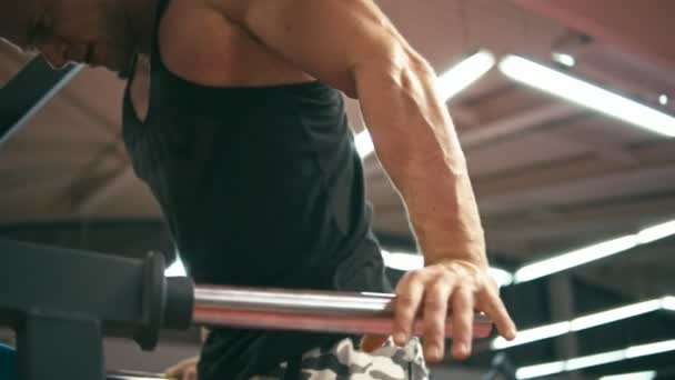 Culturista en el gimnasio haciendo inmersión vertical — Vídeo de stock