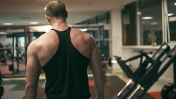 Bodybuilder marche dans la salle de gym — Video