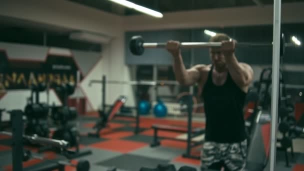 Bodybuilder beim Hantelheben vorne — Stockvideo