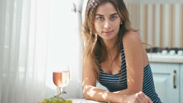 Mujer joven en la cocina con vaso de vino — Vídeos de Stock