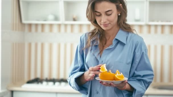 Jonge vrouw eten oranje — Stockvideo