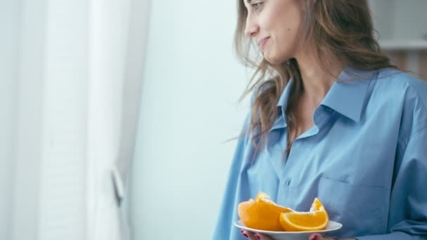 Mujer joven comiendo naranja — Vídeo de stock