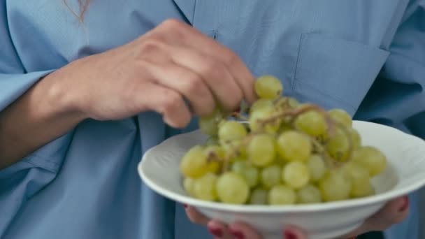 Молода жінка їсть зелений виноград — стокове відео