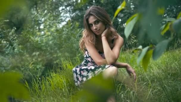 Young woman sitting on grass — Stock Video