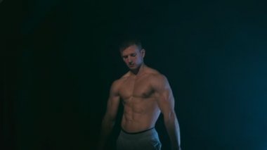 Siyah, mavi arka plan üzerinde duman ile poz fitness adam