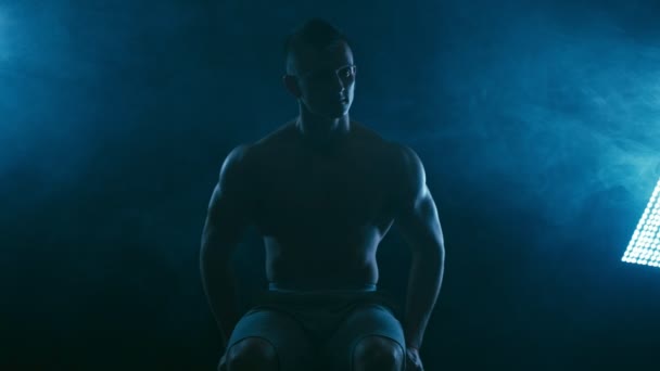 Fitness Mannen Svart Poserar Med Blå Rök Bakgrund — Stockvideo