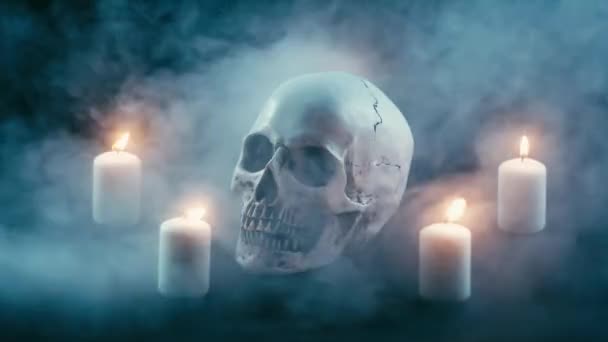 Calavera entre velas, tema de Halloween — Vídeo de stock