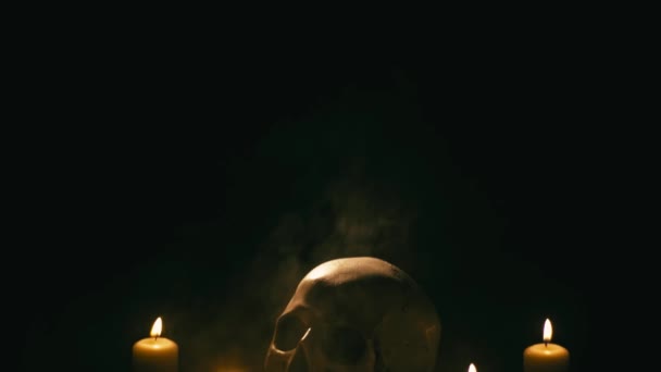 Caveira entre velas, tema de Halloween — Vídeo de Stock