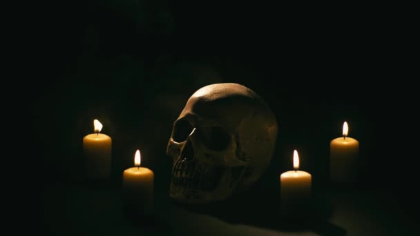 Caveira entre velas, tema de Halloween — Vídeo de Stock