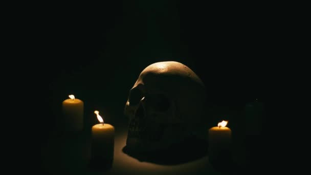 Calavera entre velas, tema de Halloween — Vídeos de Stock