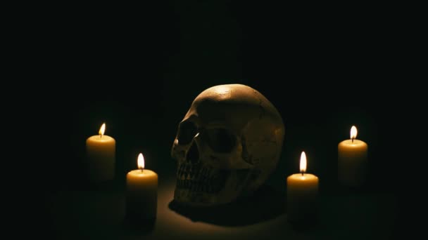 Totenkopf zwischen Kerzen, Halloween-Thema — Stockvideo