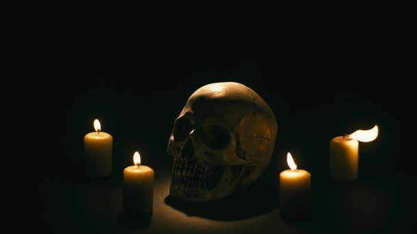 Totenkopf zwischen Kerzen, Halloween-Thema — Stockvideo