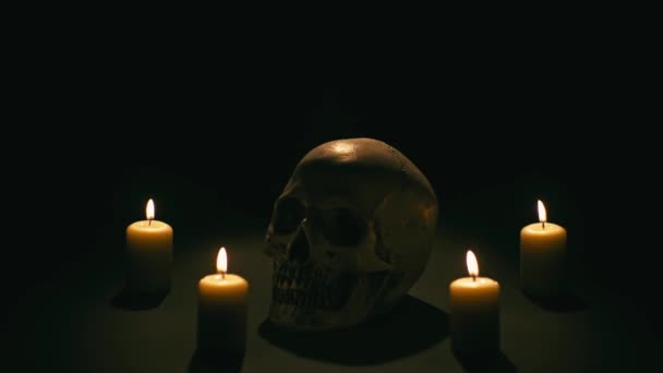 Calavera entre velas, tema de Halloween — Vídeo de stock