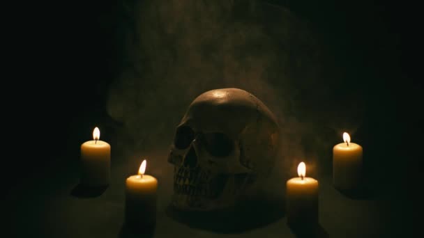 Череп між свічками, тема Хеллоуїна — стокове відео
