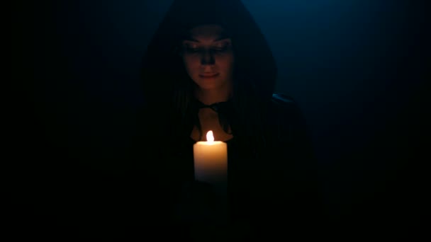 Donna in mantello di balck con candela — Video Stock