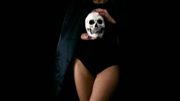 Woman in black cloack holding skull — Stock Video