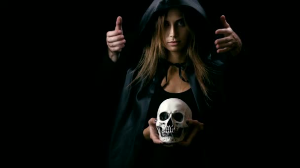 Woman in black cloack holding skull — Stock Video