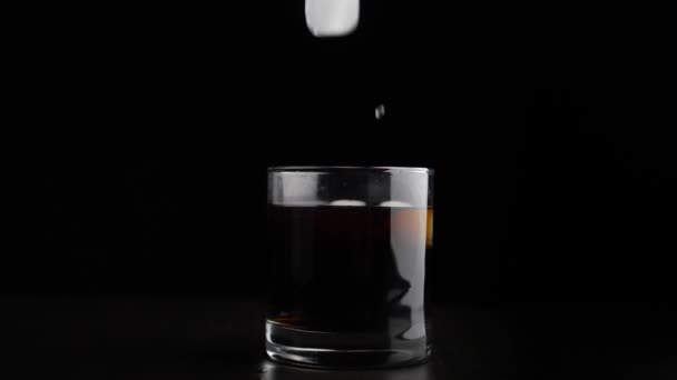 Toevoegen ijs in alcohol in glas — Stockvideo