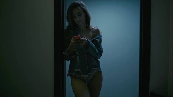 Jeune femme avec smartphone dans le couloir — Video