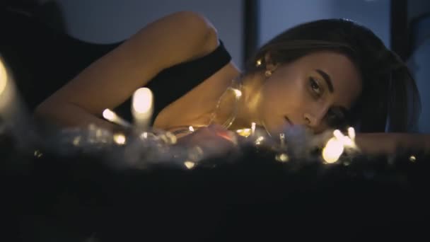 Ung vacker kvinna på golvet med ljus dekoration — Stockvideo