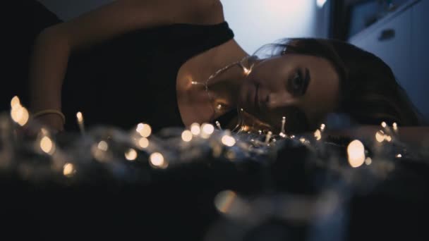 光の装飾が付いている床に若くてきれいな女性 — ストック動画