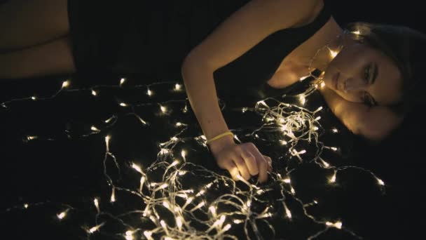 光の装飾が付いている床に若くてきれいな女性 — ストック動画
