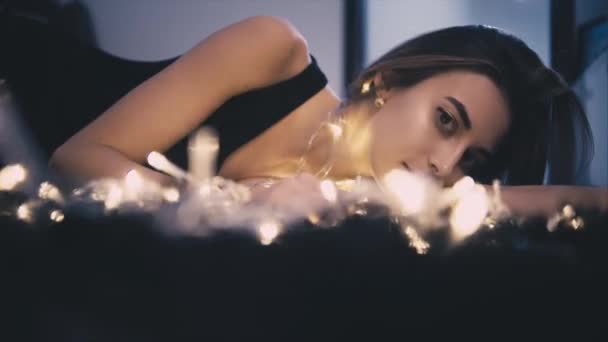 Wanita cantik muda di lantai dengan dekorasi cahaya — Stok Video