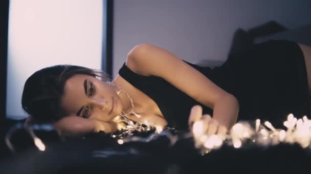 Young beautiful woman on floor with light decoration — Stock Video