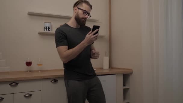 Бородатий чоловік з смартфоном танцює — стокове відео
