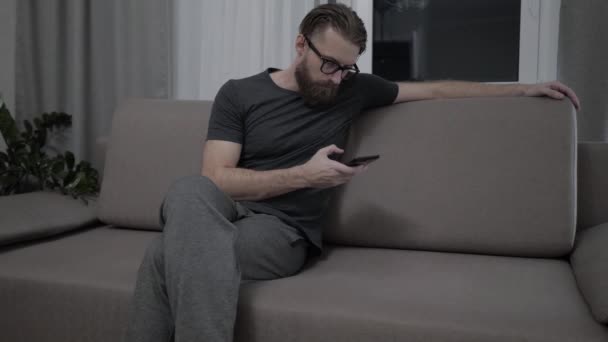 ハンサムなひげを生やした男のソファーでリラックス — ストック動画