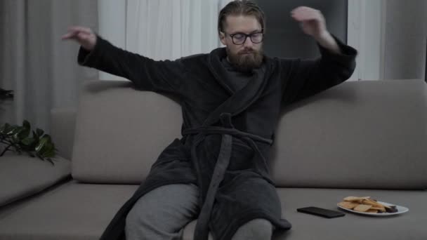 Όμορφος γενειοφόρος άνδρας, χαλαρώνοντας στον καναπέ — Αρχείο Βίντεο
