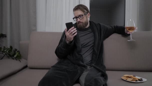 Hombre barbudo guapo relajándose en el sofá — Vídeo de stock