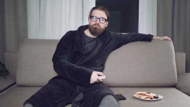 Красивий бородатий чоловік дивиться телевізор — стокове відео