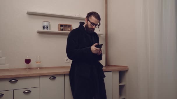 Бородатий чоловік зі смартфоном слухає музику — стокове відео