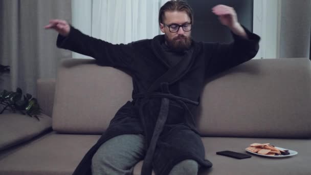 Knappe bebaarde man ontspannen op de sofa — Stockvideo