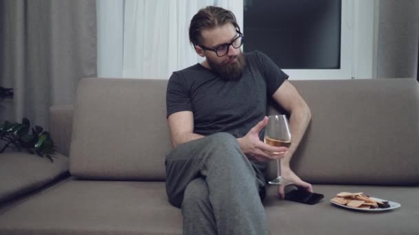 Yakışıklı sakallı adam kanepede rahatlatıcı — Stok video